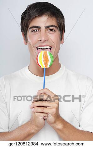 Portrait of a man licking a lollipop View Large Photo Image Picture - Portrait of a man licking a lollipop. Fotosearch