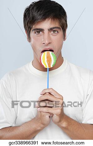 Portrait of a man licking a lollipop View Large Photo Image Stock Image - Portrait of a man licking a lollipop. Fotosearch