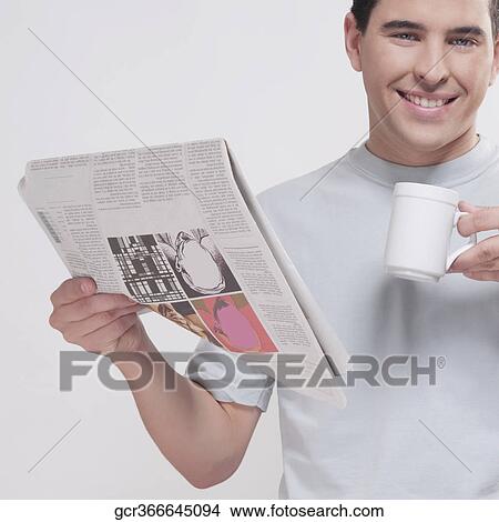Portrait of a man reading a newspaper and drinking coffee View Large Photo Image Picture - Portrait of a man reading a newspaper and drinking coffee. Fotosearch