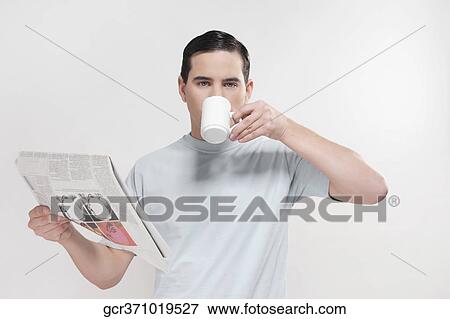 Portrait of a man reading a newspaper and drinking coffee View Large Photo Image Stock Photo - Portrait of a man reading a newspaper and drinking coffee. Fotosearch