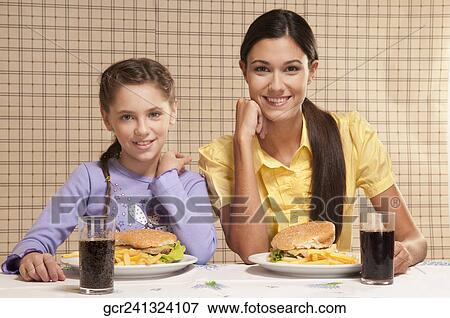 Portrait of a mother and daughter with burgers and fries View Large Photo Image Stock Photo - Portrait of a mother and daughter with burgers and fries. Fotosearch