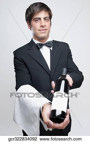 Portrait of a waiter holding a bottle of wine View Large Photo Image Stock Image - Portrait of a waiter holding a bottle of wine. Fotosearch