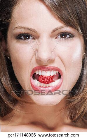 Stock Photograph - Portrait of a woman biting a raspberry. Fotosearch