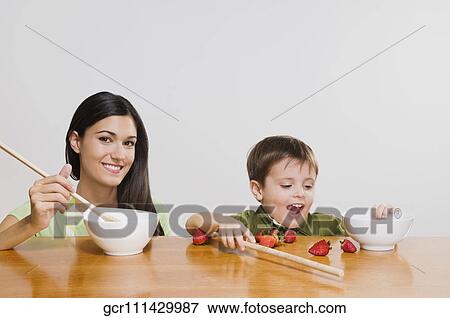 Stock Photo - Portrait of a woman cooking with her son. Fotosearch