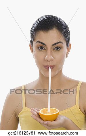 Portrait of a woman drinking from an orange with a straw View Large Photo Image Stock Image - Portrait of a woman drinking from an orange with a straw. Fotosearch