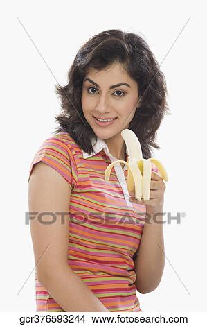 Picture - Portrait of a woman eating a banana. Fotosearch