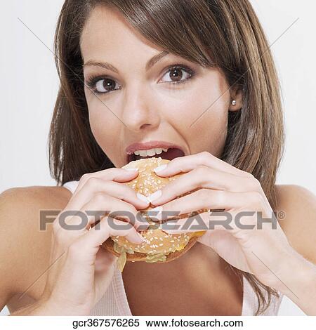Portrait of a woman eating a hamburger View Large Photo Image Stock Photography - Portrait of a woman eating a hamburger. Fotosearch