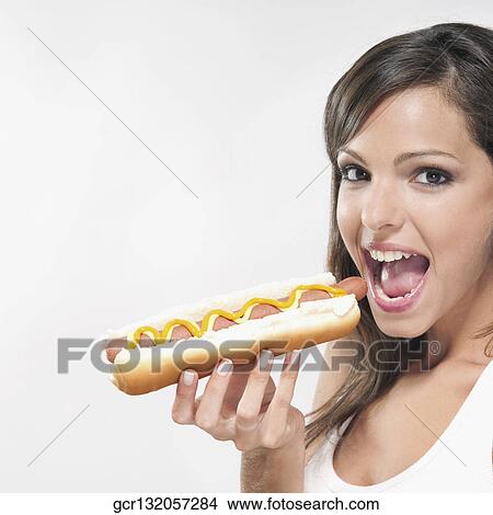 Portrait of a woman eating a hot dog View Large Photo Image Picture - Portrait of a woman eating a hot dog. Fotosearch