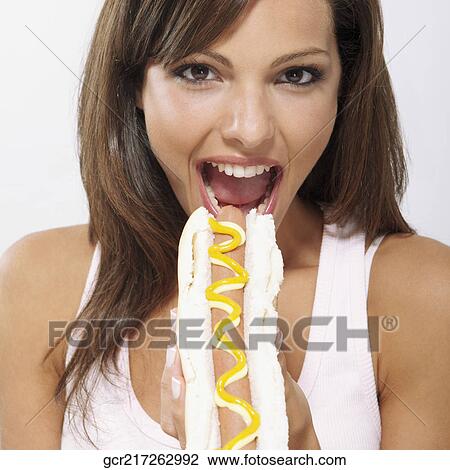 Portrait of a woman eating a hot dog View Large Photo Image Stock Image - Portrait of a woman eating a hot dog. Fotosearch