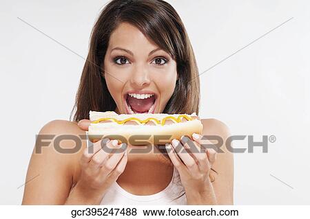 Portrait of a woman eating a hot dog View Large Photo Image Stock Photo - Portrait of a woman eating a hot dog. Fotosearch