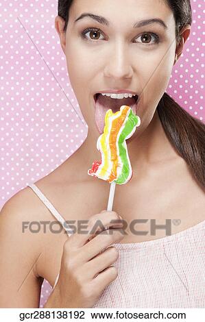 Portrait of a woman eating a lollipop View Large Photo Image Stock Image - Portrait of a woman eating a lollipop. Fotosearch