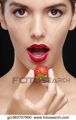 Portrait of a woman eating a strawberry View Large Photo Image Stock Image - Portrait of a woman eating a strawberry. Fotosearch