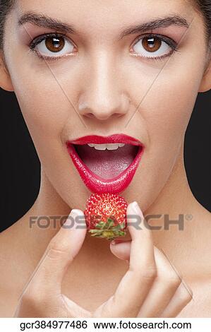 Portrait of a woman eating a strawberry View Large Photo Image Stock Photograph - Portrait of a woman eating a strawberry. Fotosearch