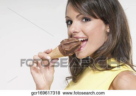 Portrait of a woman eating an ice cream cone View Large Photo Image Stock Photo - Portrait of a woman eating an ice cream cone. Fotosearch