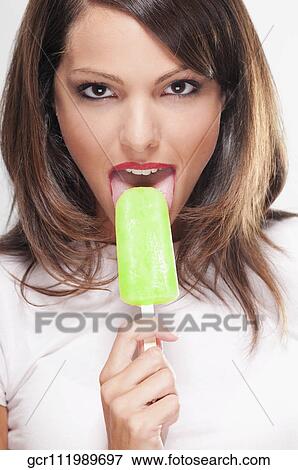 Portrait of a woman eating an ice lolly View Large Photo Image Stock Photo - Portrait of a woman eating an ice lolly. Fotosearch