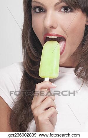 Portrait of a woman eating an ice lolly View Large Photo Image Stock Photo - Portrait of a woman eating an ice lolly. Fotosearch