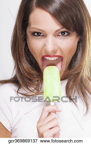 Portrait of a woman eating an ice lolly View Large Photo Image Stock Photo - Portrait of a woman eating an ice lolly. Fotosearch