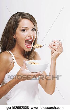 Portrait of a woman eating cereal View Large Photo Image Stock Photo - Portrait of a woman eating cereal. Fotosearch