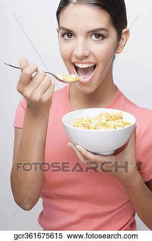 Stock Photography - Portrait of a woman eating cereal. Fotosearch