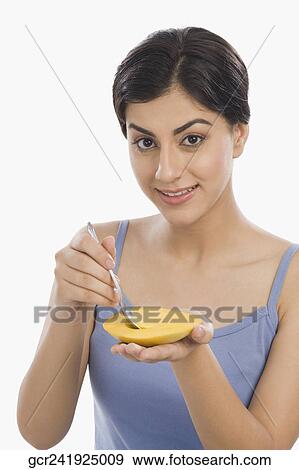Portrait of a woman eating mango with a spoon View Large Photo Image Stock Photo - Portrait of a woman eating mango with a spoon. Fotosearch