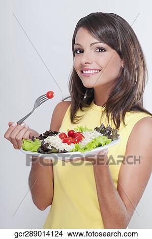 Picture - Portrait of a woman eating salad. Fotosearch
