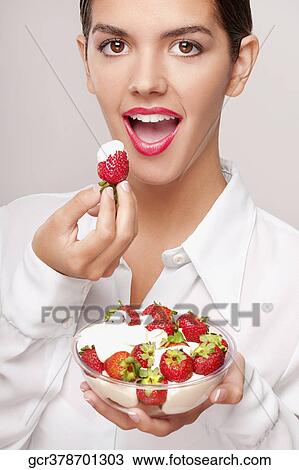 Portrait of a woman eating strawberries in cream View Large Photo Image Stock Image - Portrait of a woman eating strawberries in cream. Fotosearch