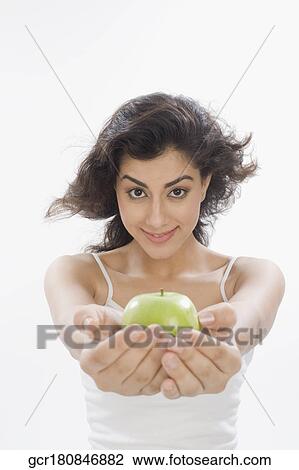 Portrait of a woman holding a green apple View Large Photo Image Stock Image - Portrait of a woman holding a green apple. Fotosearch
