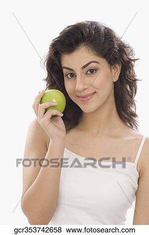 Portrait of a woman holding a green apple View Large Photo Image Stock Photo - Portrait of a woman holding a green apple. Fotosearch
