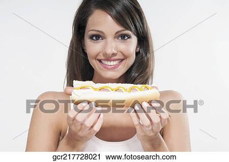Portrait of a woman holding a hot dog View Large Photo Image Stock Image - Portrait of a woman holding a hot dog. Fotosearch
