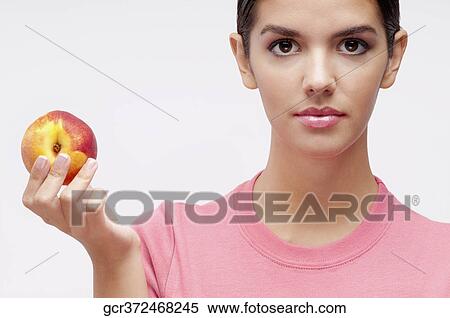 Portrait of a woman holding a peach View Large Photo Image Stock Photography - Portrait of a woman holding a peach. Fotosearch