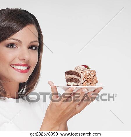 Portrait of a woman holding a plate of chocolate pastry View Large Photo Image Stock Image - Portrait of a woman holding a plate of chocolate pastry. Fotosearch