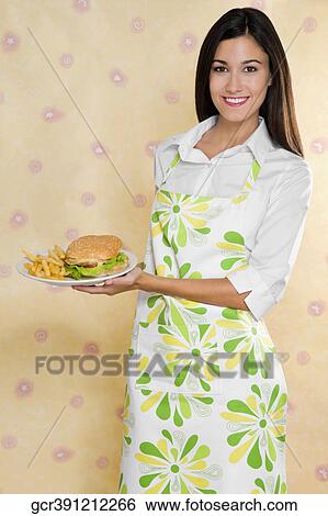 Stock Photograph - Portrait of a woman holding a plate of burger and fries. Fotosearch