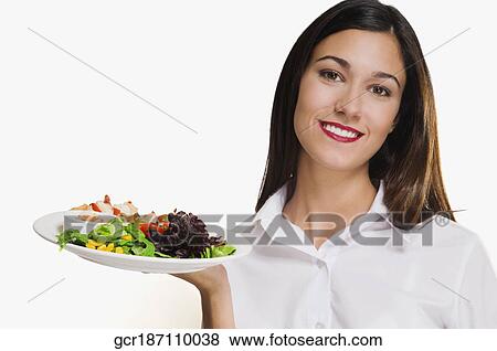 Stock Photo - Portrait of a woman holding a platter of shish kebabs. Fotosearch
