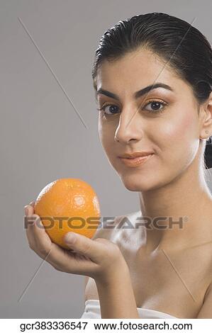 Portrait of a woman holding an orange View Large Photo Image Stock Photo - Portrait of a woman holding an orange. Fotosearch