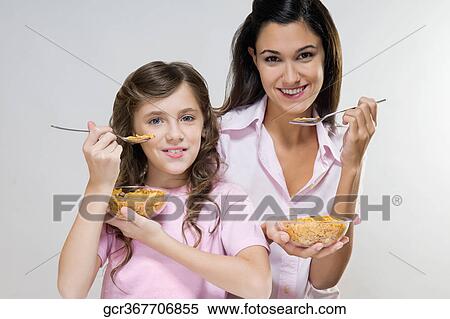 Portrait of mother and daughter eating cereal View Large Photo Image Stock Photography - Portrait of mother and daughter eating cereal. Fotosearch