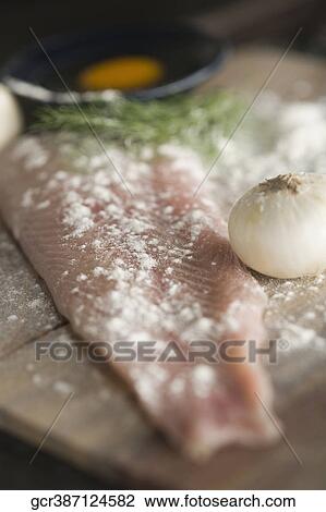Stock Image - Slice of fish with egg yolk and onion. Fotosearch