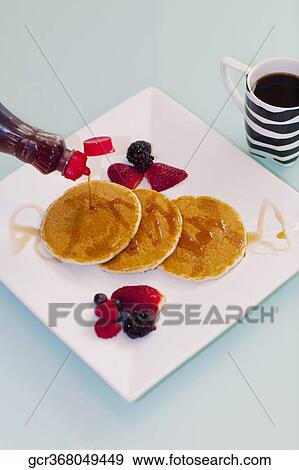 Syrup being poured on pancakes View Large Photo Image Stock Photo - Syrup being poured on pancakes. Fotosearch