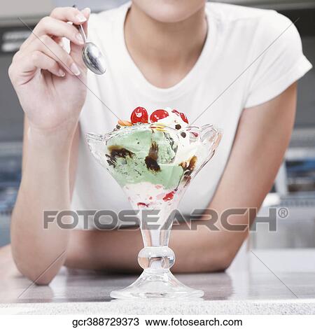 Teenage girl eating an ice cream in an ice cream parlor View Large Photo Image Stock Image - Teenage girl eating an ice cream in an ice cream parlor. Fotosearch