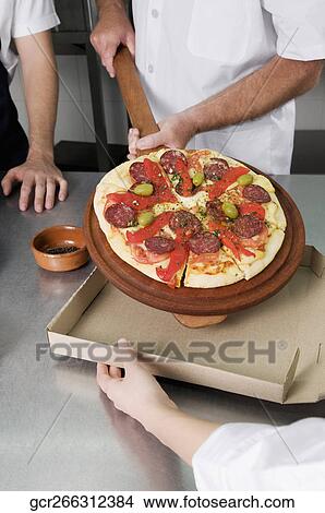 Three chefs preparing pizza in the kitchen View Large Photo Image Picture - Three chefs preparing pizza in the kitchen. Fotosearch
