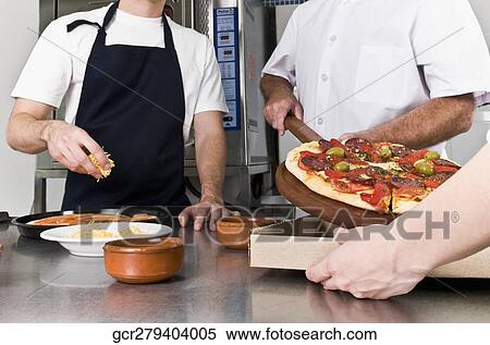 Three chefs preparing pizza in the kitchen View Large Photo Image Stock Photography - Three chefs preparing pizza in the kitchen. Fotosearch