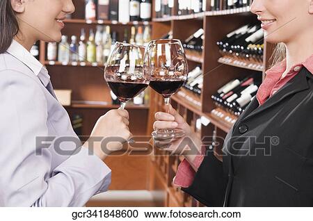 Two businesswomen toasting with wine in a bar View Large Photo Image Stock Image - Two businesswomen toasting with wine in a bar. Fotosearch