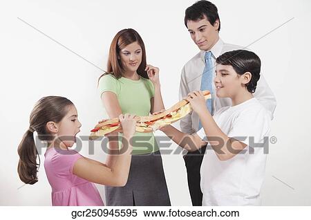 Two children eating a submarine sandwich in front of their parents View Large Photo Image Stock Photography - Two children eating a submarine sandwich in front of their parents. Fotosearch