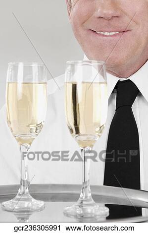 Waiter holding a tray of champagne flutes View Large Photo Image Stock Image - Waiter holding a tray of champagne flutes. Fotosearch