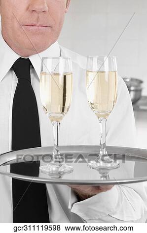 Waiter holding a tray of champagne flutes View Large Photo Image Stock Photo - Waiter holding a tray of champagne flutes. Fotosearch