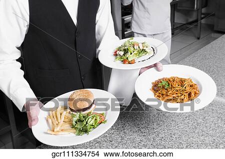 Picture - Waiter holding plates of foods. Fotosearch