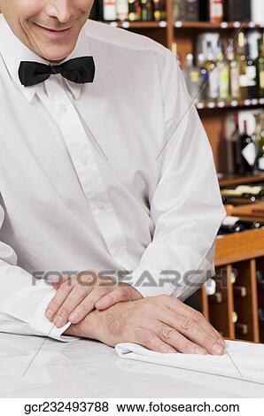 Waiter leaning against a bar counter View Large Photo Image Stock Photo - Waiter leaning against a bar counter. Fotosearch