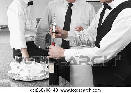 Waiter opening a wine bottle View Large Photo Image Stock Image - Waiter opening a wine bottle. Fotosearch