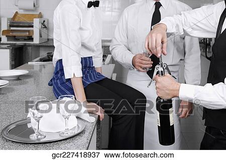 Waiter opening a wine bottle View Large Photo Image Stock Photo - Waiter opening a wine bottle. Fotosearch