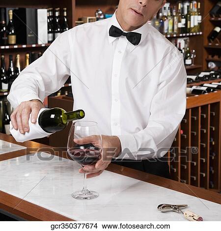 Waiter pouring red wine into a wine glass in a bar View Large Photo Image Picture - Waiter pouring red wine into a wine glass in a bar. Fotosearch
