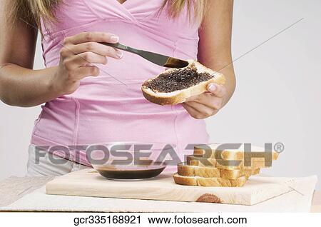 Woman applying chocolate sauce on a slice of bread View Large Photo Image Stock Image - Woman applying chocolate sauce on a slice of bread. Fotosearch